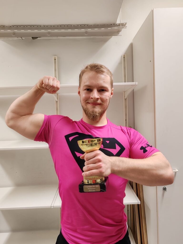 Joonatan Merenluoto holding their trophy at Formis gym.